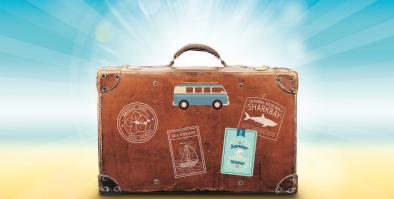 Suitcase on sand with sunlight behind it