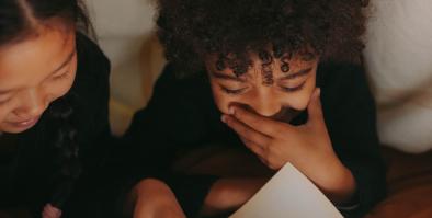Two children reading a book.