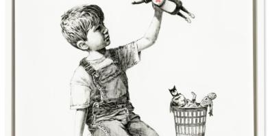 A child holding up a toy that portrays a nurse as a superhero. 