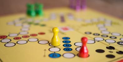 Board game with red, yellow, green and purple game pieces.