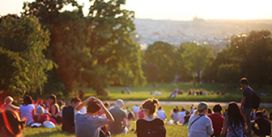 group of people sitting in a park watching the sunset.