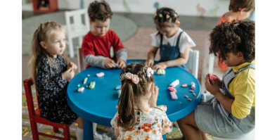 5 kids using clay at a small round table