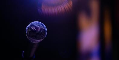Free standing microphone in front of a blurred out stage