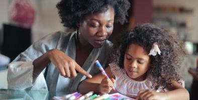 Mother assisting child with writing