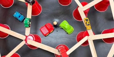 Examples of materials including red plastic cups and wooden sticks all touching.