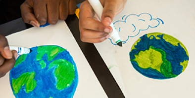 students drawing pictures of Earth with markers.