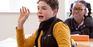 student raising hand in class.