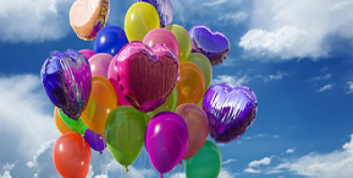 An assortment of balloons floating into the sky