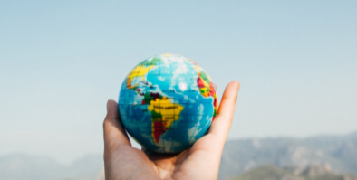 Hand holding a small globe.